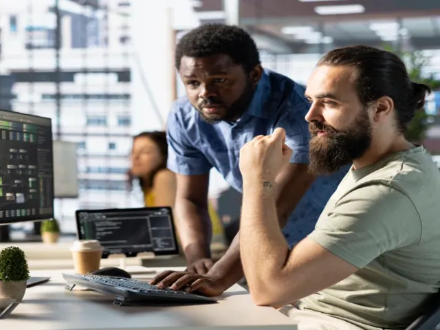 Escritório com dois programadores fazendo reunião e desenvolvendo um software